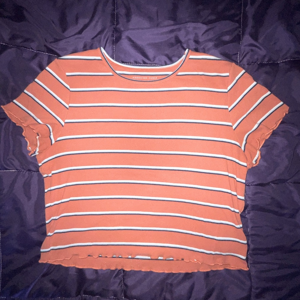 A striped cropped top. With colors orange, white, and black. Perfect for fall.
